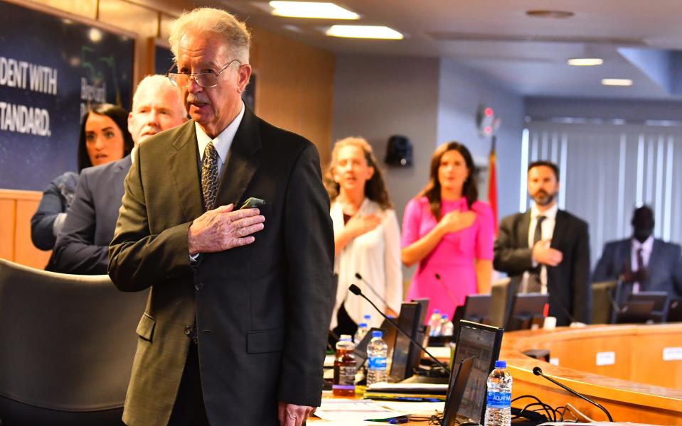 Interim Superintendent Robert Schiller, foreground, seen with school board members saying the Pledge of Allegiance at the March 28 school board meeting, was place on administrative leave just before the end of the meeting.