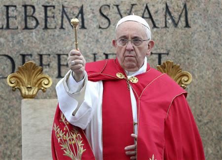 Pope Francis sprinkles holy water with an aspergillum as a blessing during the Palm Sunday mass at Saint Peter's Square at the Vatican April 13, 2014. REUTERS/Alessandro Bianchi