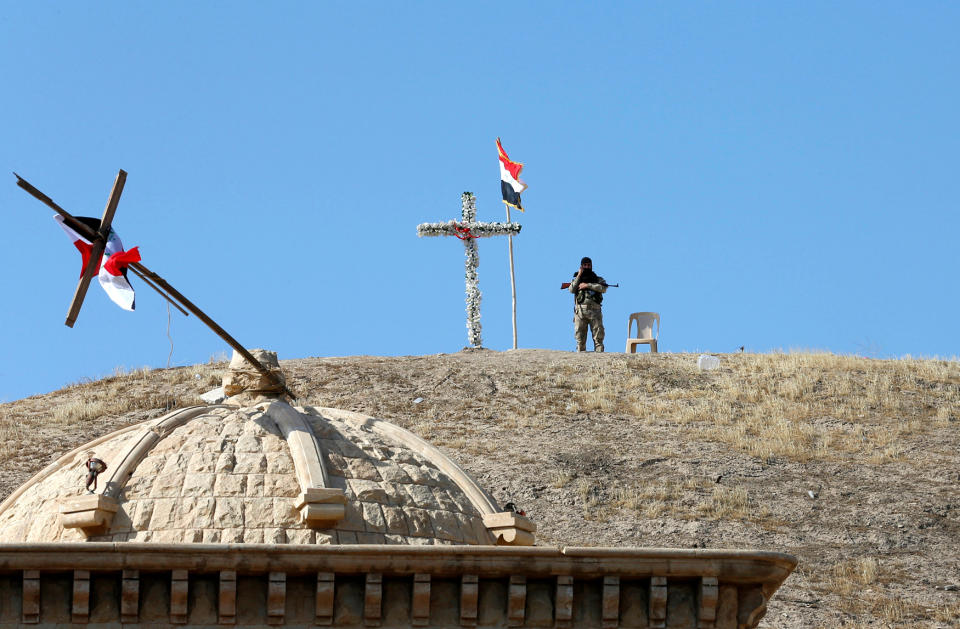 A soldier guards the church of Saint Barbara after it was recaptured from ISIS