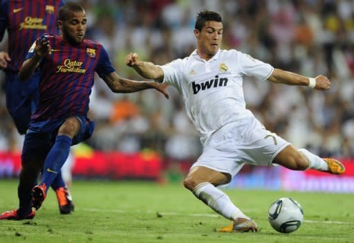 Real Madrid forward Cristiano Ronaldo (right) vies with Barcelona's defender Dani Alves during their Spanish Supercup match Real Madrid at the Santiago Bernabeu stadium in Madrid, August 2011. Spanish giants Real Madrid claimed world-beating revenue for the sports world in 2010/11
