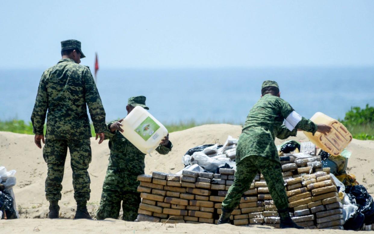 Mexican Navy and anti-narcotics personnel burn packs with part of a seizure of 5 tons of cocaine and marijuana - AFP