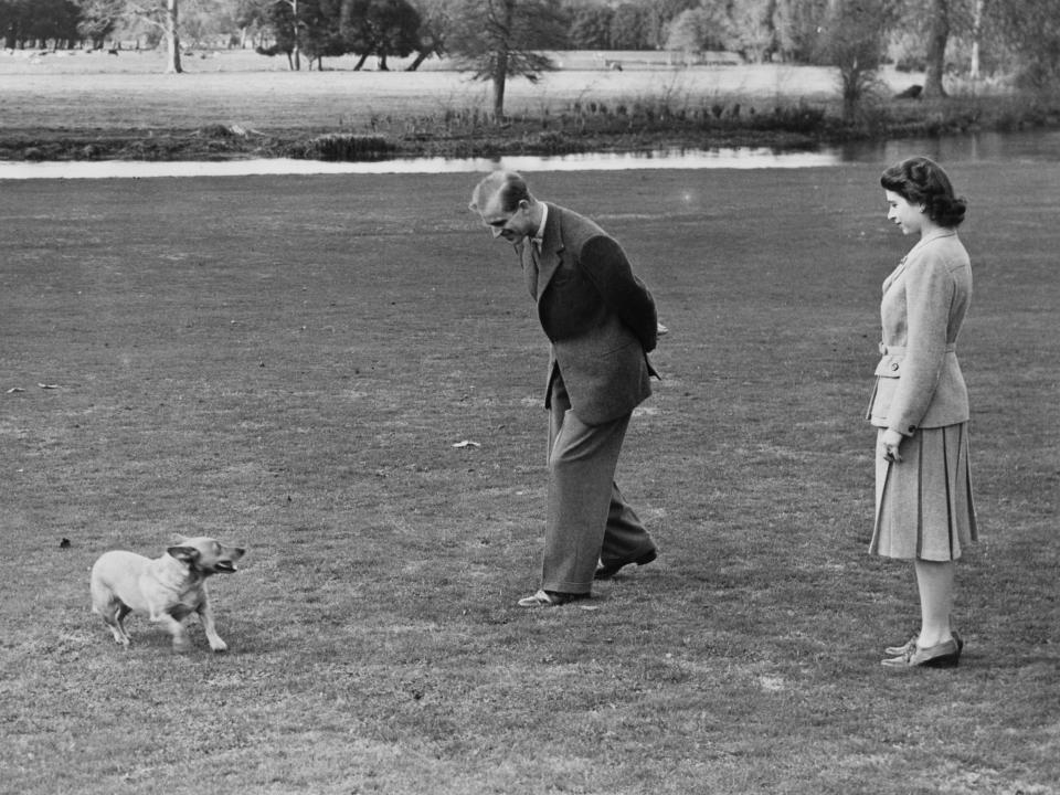 Prince Philip and Queen Elizabeth play with a corgi in 1947.