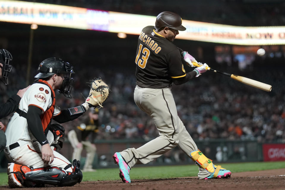 San Diego Padres' Manny Machado (13) hits a two-run single in front of San Francisco Giants catcher Patrick Bailey during the 10th inning of a baseball game in San Francisco, Wednesday, Sept. 27, 2023. (AP Photo/Jeff Chiu)