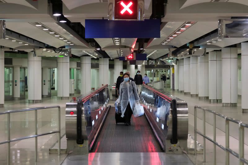 Passengers wear face masks as they arrive to the Lo Wu MTR station, before the closing of the Lo Wu border following the coronavirus outbreak, in Hong Kong