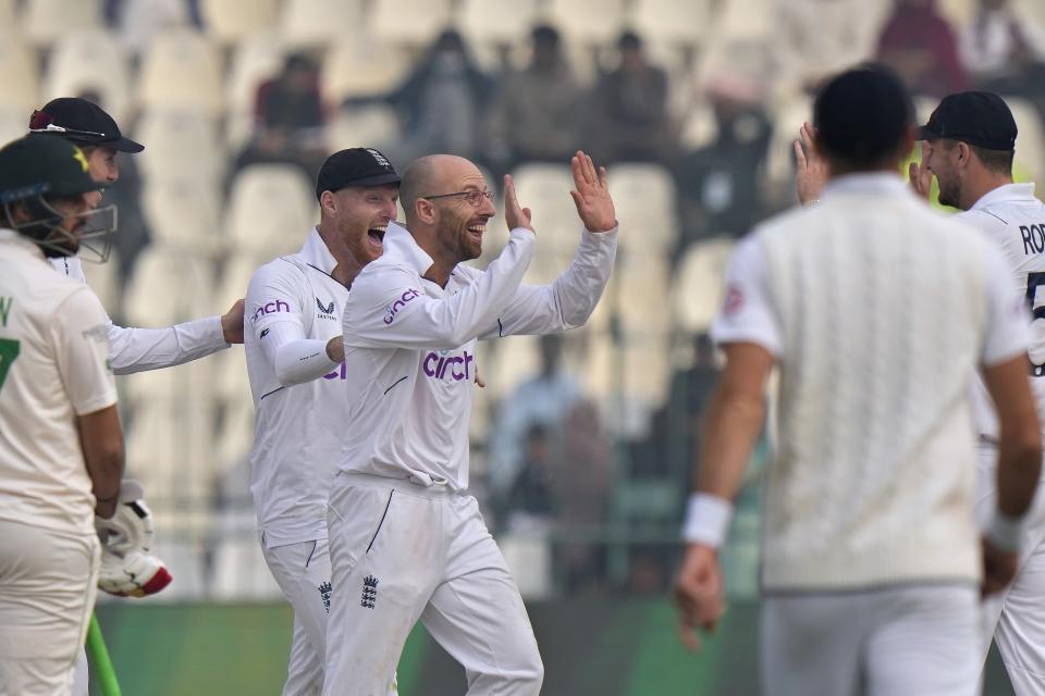 England's Jack Leach, center, celebrates with teammate after taking the wicket of Pakistan Muhammad Nawaz during the second day of the second test cricket match between Pakistan and England, in Multan, Pakistan, Saturday, Dec. 10, 2022. (AP Photo/Anjum Naveed)