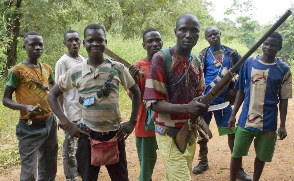 FILE - In this Tuesday, Nov. 26, 2013 file photo, fighters from a Christian militia movement known as the "anti-balaka" display their makeshift weaponry in the village of Boubou, halfway between the towns of Bossangoa and Bouca, in the Central African Republic. Central African Republic and 14 rebel groups signed a peace deal on Wednesday, Feb. 6, 2019 even as some expressed alarm about the possible suspension of prosecutions after five years of bloody conflict. (AP Photo/Florence Richard, File)