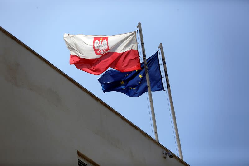 FILE PHOTO: Poland's flag flutters near the European Union flag on the building of the Polish Embassy in Tel Aviv, Israel
