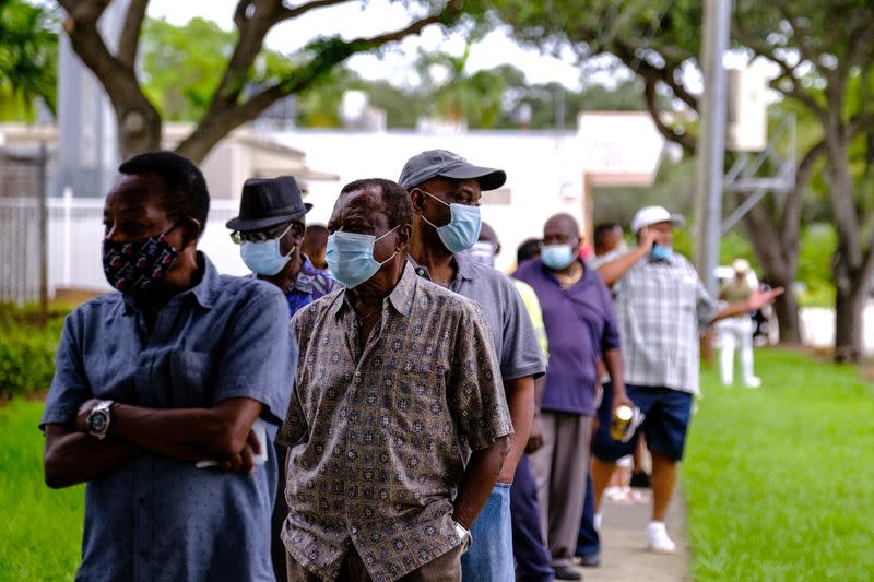 Gente hace fila en la mesa de votación de la Biblioteca Pública de North Miami cuando comienza la votación anticipada antes de las elecciones en Miami, Florida, EEUU. 19 de octubre de 2020.