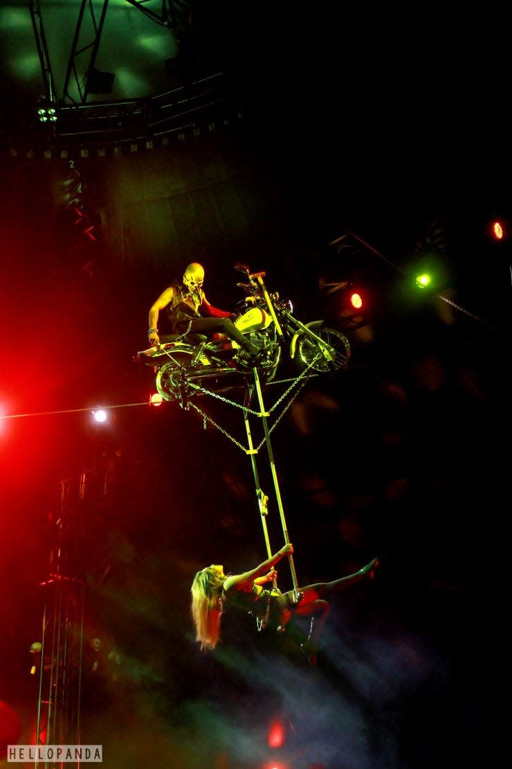 A motorcycle acrobat carries another under a high wire at a Paranormal Cirque show. The troupe is visiting Polk County for the first time next week, at Lake Wales' Eagle Ridge Mall.