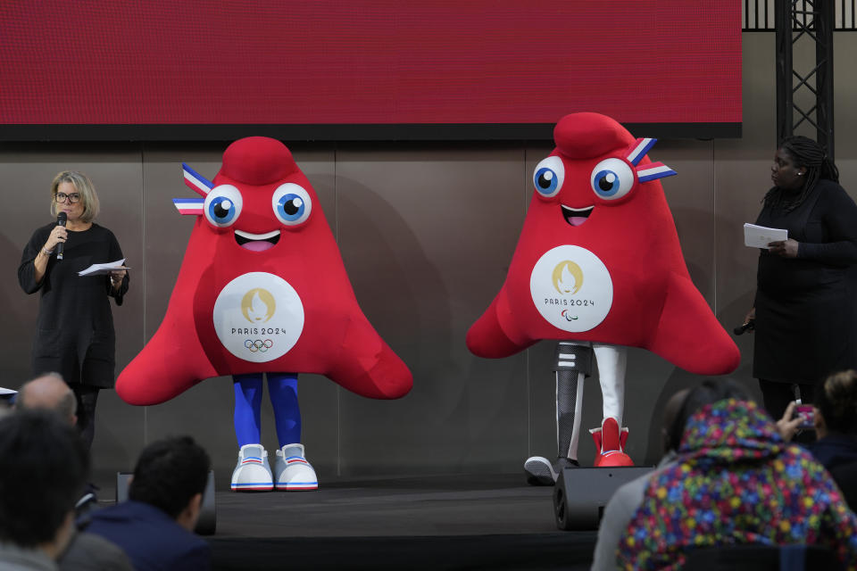 The mascots of the 2024 Paris Olympic Games, left, and Paralympic Games are presented Monday, Nov. 14, 2022 in Saint-Denis, outside Paris. The mascot, a Phrygian cap, also known as a liberty cap, is an updated version of a conical hat worn in antiquity in places such as Persia, the Balkans, Thrace, Dacia and Phrygia, where the name originates, in modern day Turkey. It later became a symbol of the pursuit of liberty in the French Revolution, and is still worn by the figure of Marianne, the national personification of France since that time. (AP Photo/Thibault Camus)