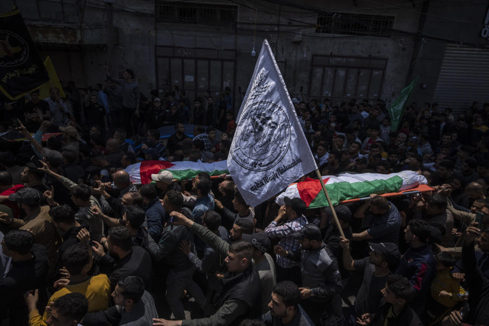 Mourners carry the bodies of Palestinians who were killed in Israeli airstrikes, during their funeral in Gaza City, Tuesday, May 9, 2023. The airstrikes killed three senior commanders of the militant Islamic Jihad group and 10 other people, including two of the commanders' wives, several of their children and others nearby. (AP Photo/Fatima Shbair)