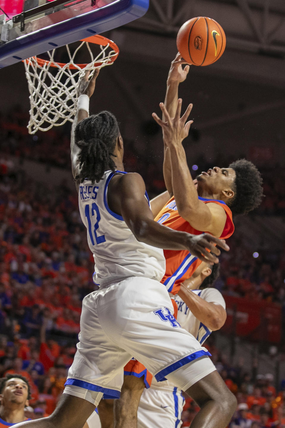 Florida guard Zyon Pullin (0) shoots around Kentucky Wildcats guard Antonio Reeves (12) during the first half of an NCAA college basketball game Saturday, Jan. 6, 2024, in Gainesville, Fla. (AP Photo/Alan Youngblood)