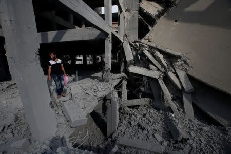 A Palestinian man looks at a building that was destroyed by Israeli air strikes in Gaza City July 15, 2018. REUTERS/Suhaib Salem