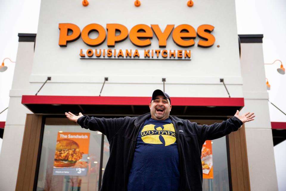 Javier Valdez, also known as Holland's "Popeyes Guy," poses for a photo outside the restaurant ahead of its official opening Tuesday, Dec. 28, 2021.