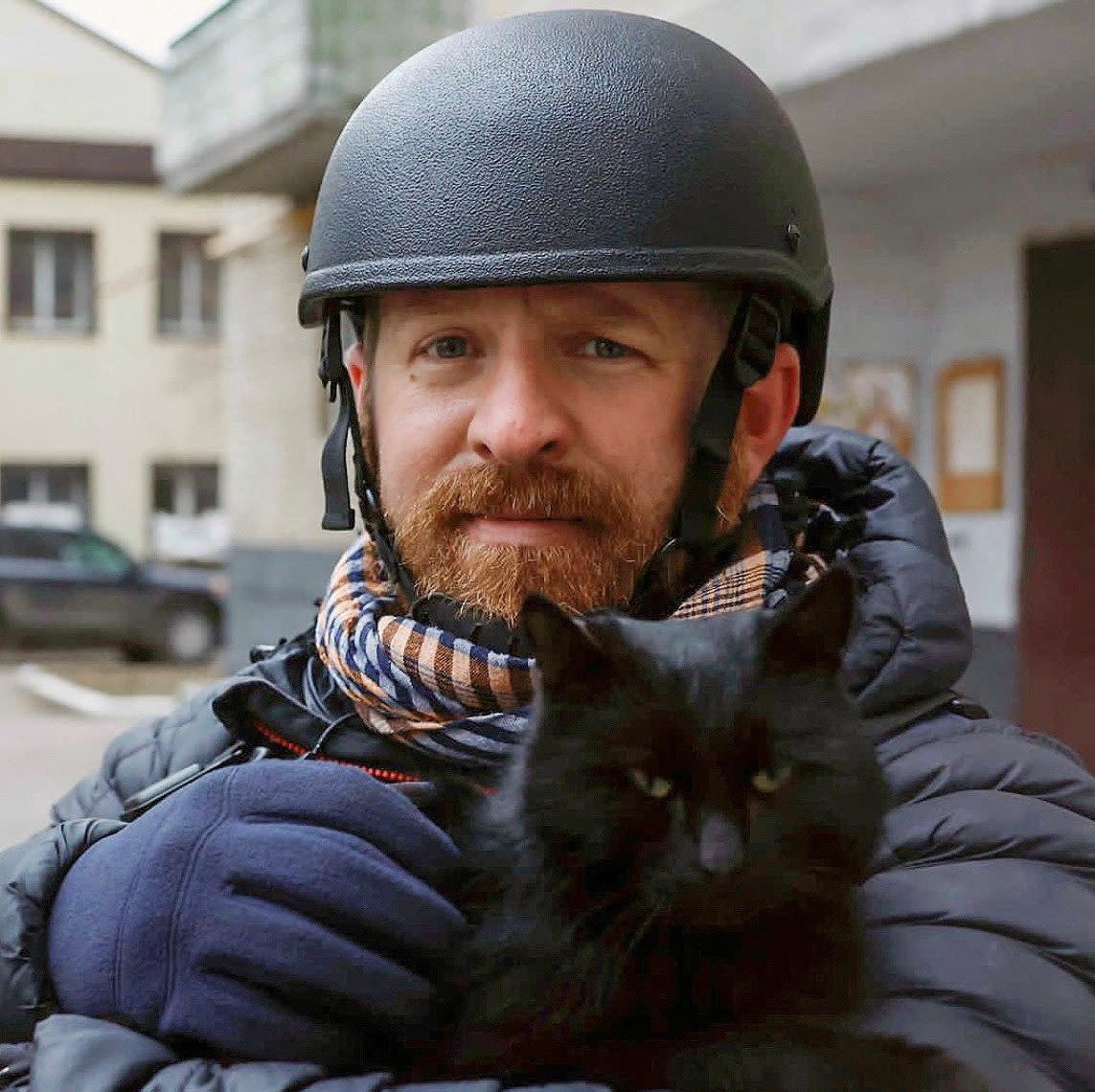 Ryan Evans holds a cat in Kyiv