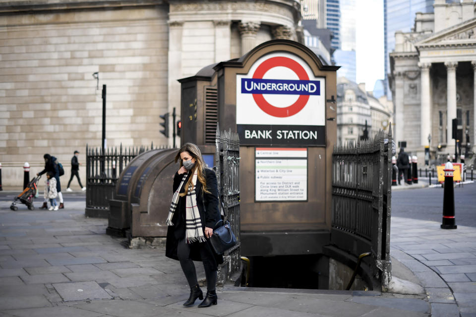 A woman wears a face mask as she steps out of Bank underground station, in London. Photo: Alberto Pezzali/AP