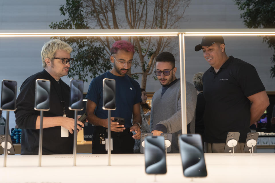 File - Shoppers look at Apple's new iPhone 15 models at an Apple Store in Los Angeles on Sept. 22, 2023. On Wednesday, the Commerce Department releases U.S. retail sales data for October. (AP Photo/Jae C. Hong, File)