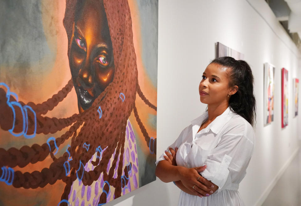 <p>A HOFA Gallery employee looks at 'Serena' by Chinaza Agbor during the preview of the Mother of Mankind exhibition, showcasing 18 black female artists, curated by Adora Mba, at the HOFA Gallery (House Of Fine Art), in Mayfair, London. Picture date: Wednesday July 21, 2021.</p>
