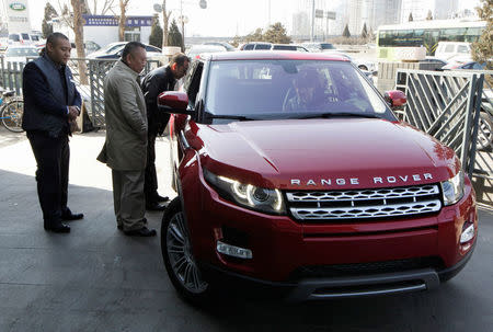 Customers look at a Range Rover Evoque car outside a dealership in Beijing, China, February 17, 2012. REUTERS/Jason Lee/File Photo