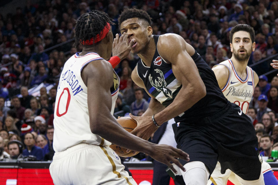 Milwaukee Bucks' Giannis Antetokounmpo, right, drives to the basket as Philadelphia 76ers' Josh Richardson, left, will accidentally pokes him in the eye during the second half of an NBA basketball game, Wednesday, Dec. 25, 2019, in Philadelphia. The 76ers won 121-109. (AP Photo/Chris Szagola)