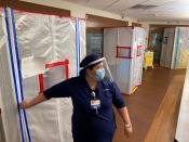 Nurse Katelyn Sofley stands at the entrance to a negative pressure ICU hospital room, where COVID-19 patients are treated, at St John's Regional Medical Center in Oxnard