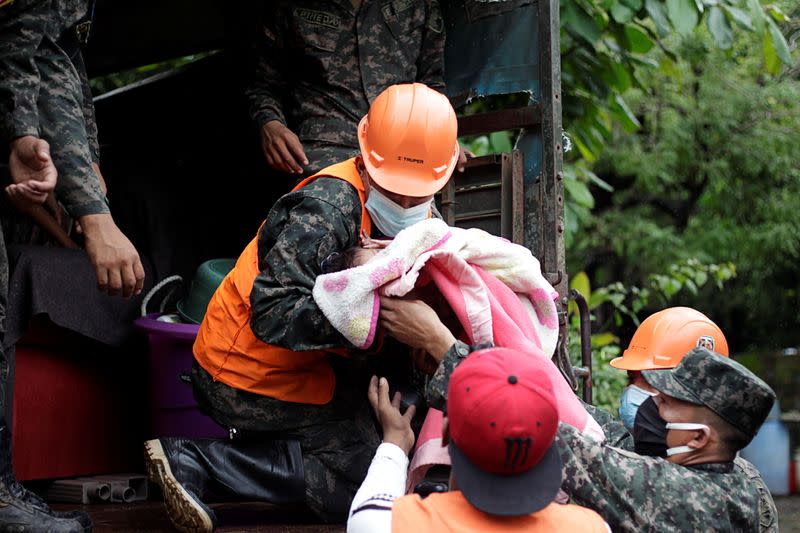 Honduran soldiers hold a baby as they evacuate residents in anticipation of heavy rains as Hurricane Iota approaches, in Marcovia