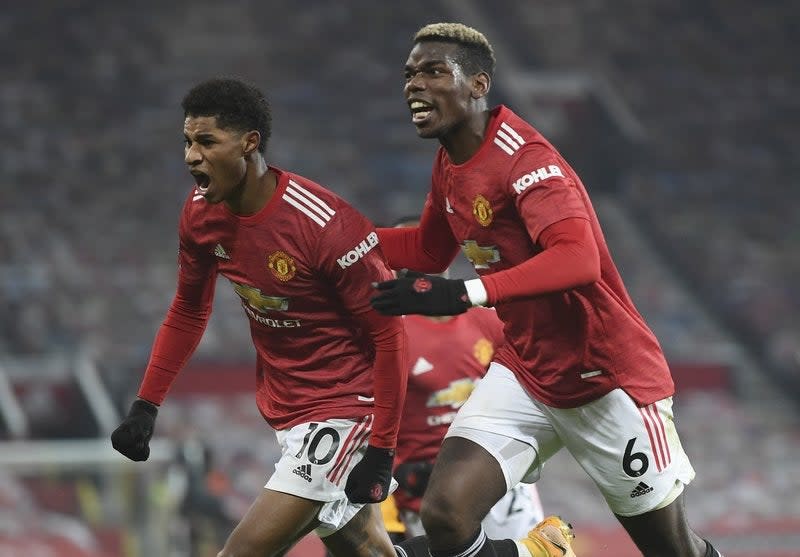 Marcus Rashford (izquierda), del Manchester United, festeja con Paul Pogba tras anotar ante el Wolverhampton en un encuentro de la Liga Premier inglesa, llevado a cabo el martes 29 de diciembre de 2020 (Michael Regan, Pool via AP) (Michael Regan, Pool via AP)