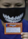 A child shows his vaccination card after getting a dose of the Coronavac COVID-19 vaccine at his school in Santiago, Chile, Monday, Sept. 27, 2021, during the start of vaccinations in schools for children between ages 6 to 11. (AP Photo/Esteban Felix)