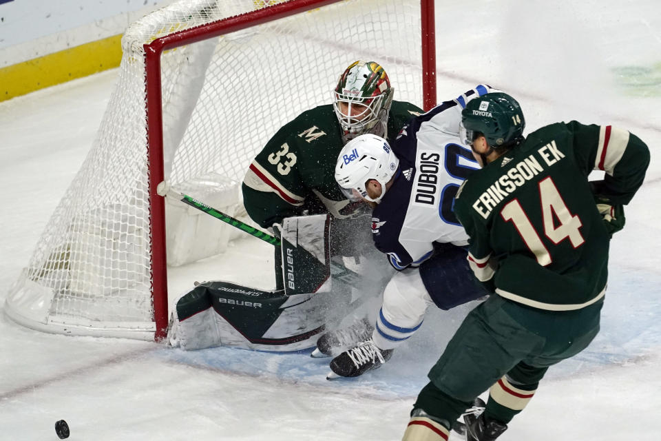 Minnesota Wild goalie Cam Talbot (33) blocks a shot by Winnipeg Jets' Pierre-Luc Dubois, center, during the first period of an NHL hockey game, Friday, Nov. 26, 2021, in St. Paul, Minn. (AP Photo/Jim Mone)