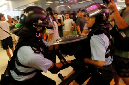 A protester is detained by the police officers at Amoy Plaza shopping mall in Kowloon Bay, Hong Kong