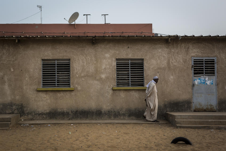 A Senegalese man waits for a polling station to open in Dakar, Senegal Sunday Feb. 24, 2019. Voters are choosing whether to give President Macky Sall a second term in office as he faces four challengers.(AP Photo/Jane Hahn)