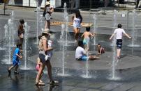 <p>Women and children play in the water fountains at the Place des Arts in Montreal, Que. on a hot summer day July 3, 2018. (Photo by Eva Hambach/AFP) </p>