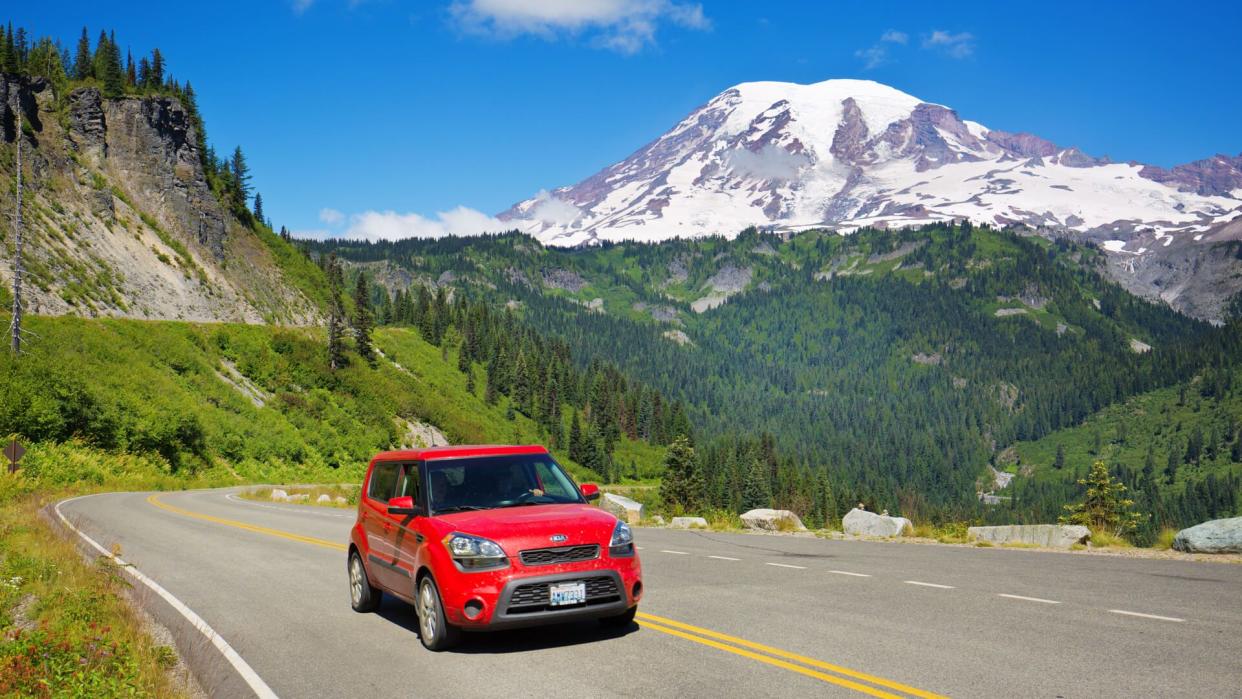 Mount Rainier National Park, Washington, USA - July 31, 2016: Visitors to Mount Rainier National Park touring the park along the scenic highway in their vehicle with Mount Rainier in the distance background.