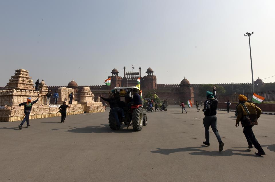 NEW DELHI, INDIA - JANUARY 26: Demonstrators at Red Fort during the farmers' tractor rally on Republic Day, on January 26, 2021 in New Delhi, India. Major scenes of chaos and mayhem at Delhi borders as groups of farmers allegedly broke barricades and police check posts and entered the national capital before permitted timings. Police used tear gas at Delhi's Mukarba Chowk to bring the groups under control. Clashes were also reported at ITO, Akshardham. Several rounds of talks between the government and protesting farmers have failed to resolve the impasse over the three farm laws. The kisan bodies, which have been protesting in the national capital for almost two months, demanding the repeal of three contentious farm laws have remained firm on their decision to hold a tractor rally on the occasion of Republic Day.(Photo by Sanjeev Verma/Hindustan Times via Getty Images)