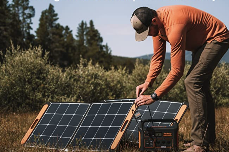 man hooking up a portable generator in the wilderness