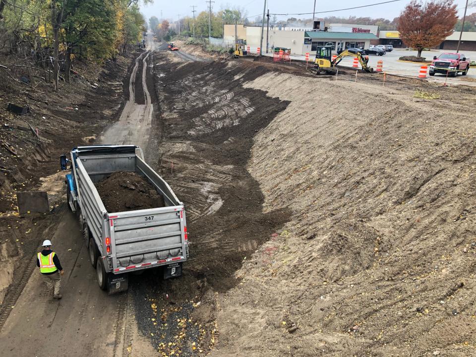 Crews move dirt Tuesday on the route of South Bend's Coal Line Trail. This is looking west from the Portage Avenue bridge, which had been obscured by trees and growth before construction began.