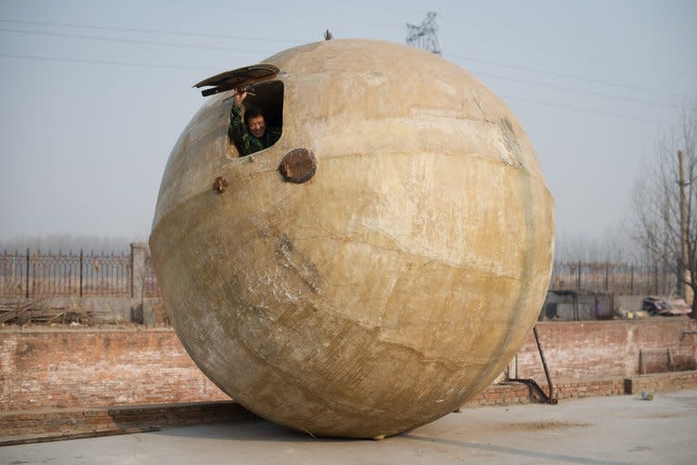 This photo taken on December 11, 2012 shows farmer Liu Qiyuan looking out from a survival pod that he built, in the village of Qiantun, south of Beijing. Liu's seven completed or under-construction pods, made using a fibreglass casing over a steel frame, have cost him 300,000 yuan ($48,000) each, he says, and are equipped with oxygen tanks, food and water supplies