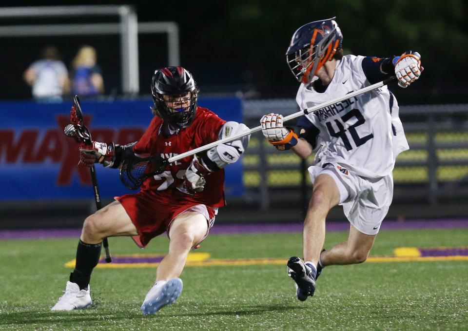 Rye's Tyler McDermott (22) drives around Manhasset's Rowan Collins (42) during the boys lacrosse state Class C semifinal at Fallon Field on the campus of the University at Albany June 9, 2023. 