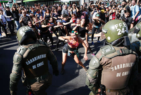 Demonstrators perform in front of riot police during a protest demanding an end to profiteering in the education system in Santiago, Chile April 19, 2018. REUTERS/Rodrigo Garrido