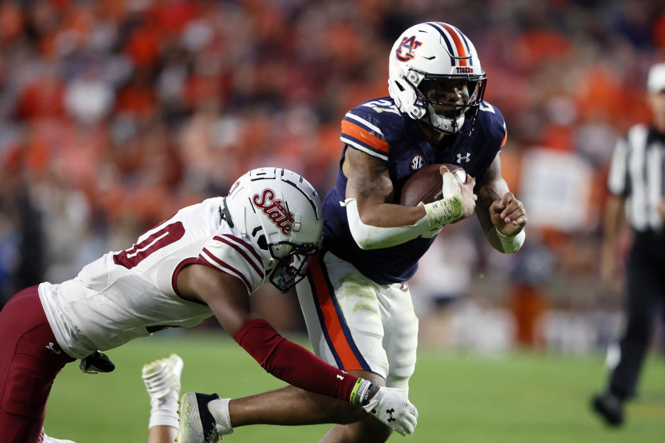 Auburn running back Jarquez Hunter (27) os tackled by New Mexico State cornerback Reggie Akles (0) as he carries the ball during the second half of an NCAA college football game Saturday, Nov. 18, 2023, in Auburn, Ala. (AP Photo/Butch Dill)