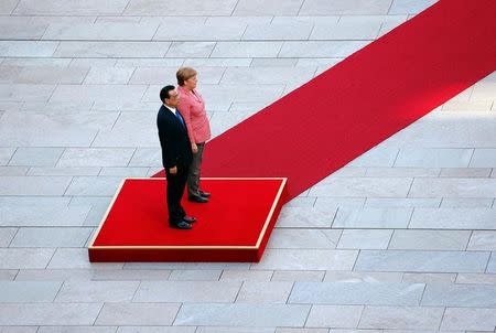 German Chancellor Angela Merkel and Chinese Premier Li Keqiang review the guard of honour during a welcome ceremony at the Chancellery in Berlin, Germany, May 31, 2017. REUTERS/Fabrizio Bensch