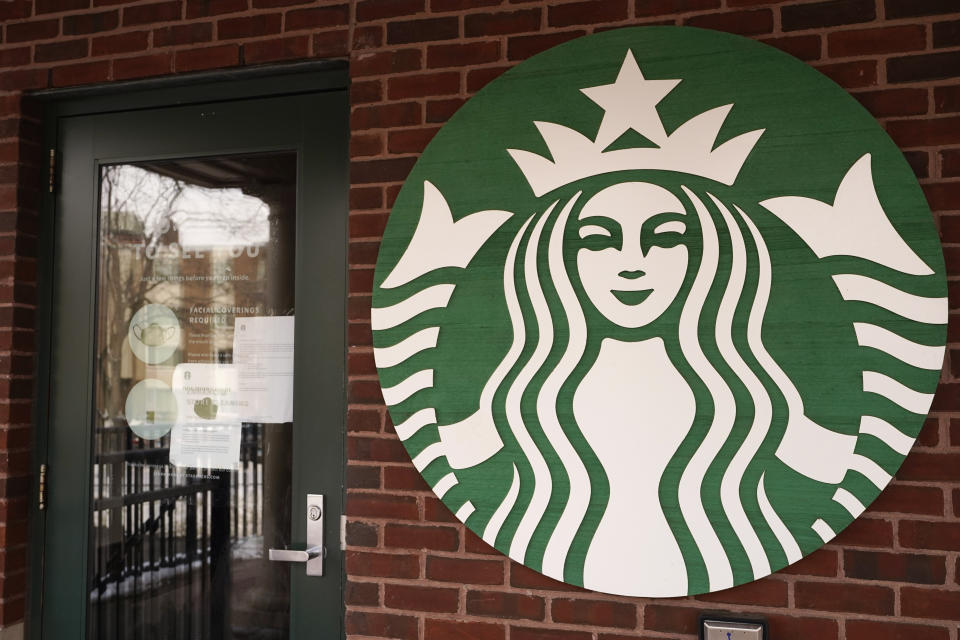 In this Jan. 6, 2021, photo, a Starbucks coffee company logo and information signs are seen at Palatine Metra train station in Palatine, Ill. Companies that would be affected by a Biden administration vaccine-or-testing requirement for workers remain on the sidelines while the Supreme Court considers whether the rule can be enforced. Since then, Starbucks has announced its own vaccine mandate saying in Dec. 2021, that all U.S. workers must be fully vaccinated by Feb. 9, 2022, or face a weekly COVID testing requirement. (AP Photo/Nam Y. Huh)