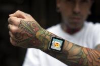 Tattoo artist Dave Hurban displays an iPod Nano, in New York, which he has attached to his arm through magnetic piercings in his wrist.