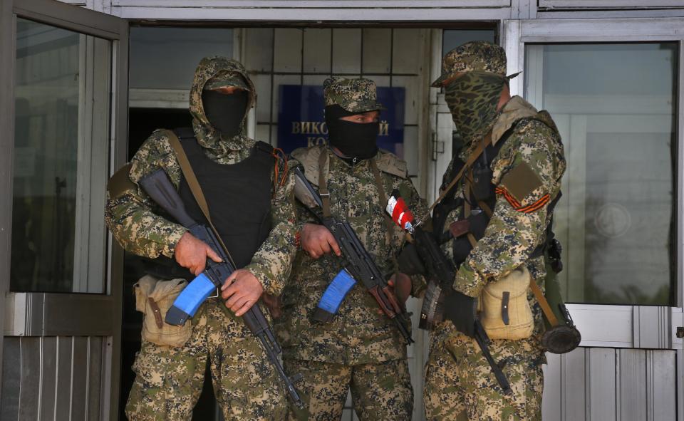 Pro Russian masked armed men guard at the city hall in Kostyantynivka, 35 kilometers (22 miles) south of Slovyansk, eastern Ukraine, Monday, April 28, 2014, after masked militants with automatic weapons seized the hall building. Ukraine's acting government and the West have accused Russia of orchestrating the unrest, which they fear Moscow could use as a pretext for an invasion. (AP Photo/Sergei Grits)