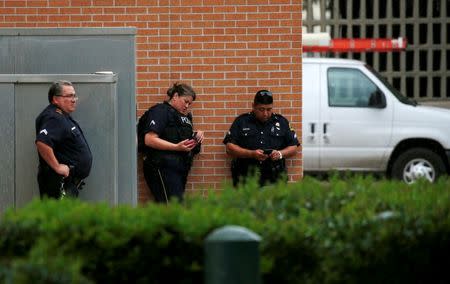 Dallas police officers stand outside a building near the Dallas Police Department headquarters after an anonymous threat was reported in Dallas, Texas, U.S. July 9, 2016. REUTERS/Carlo Allegri