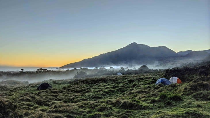 <span class="article__caption">Tents in the grass and mist pouring up Kaupo Gap before Haleakala sunset.</span> (Photo: Lyle Wilkinson/Unsplash)