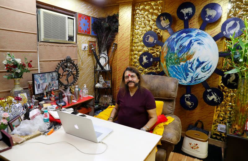 Sanjay Sharma, a mystic healer and astrologer, sits inside his office as he waits for a next client, amidst the spread of the coronavirus disease (COVID-19), in New Delhi