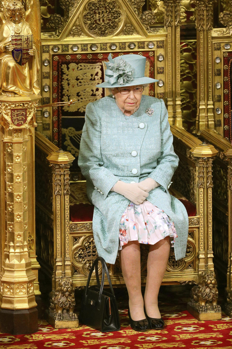 Britain's Queen Elizabeth II sits in the chamber ahead of the State Opening of Parliament, in the House of Lords at the Palace of Westminster in London, Thursday Dec. 19, 2019. Queen Elizabeth II will formally open a new session of Britain's Parliament on Thursday, with a speech giving the first concrete details of what Prime Minister Boris Johnson plans to do with his commanding House of Commons majority. (Aaron Chown, Pool via AP)