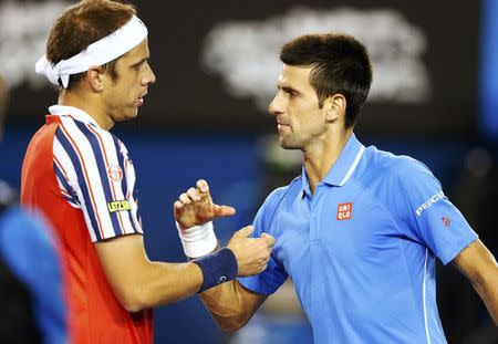 Novak Djokovic of Serbia shakes hands with Gilles Muller (L) of Luxembourg after winning their men's singles fourth round match at the Australian Open 2015 tennis tournament in Melbourne January 26, 2015. REUTERS/Athit Perawongmetha