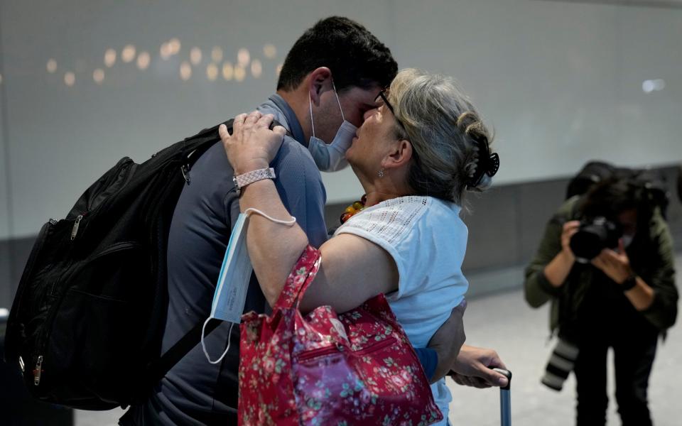 Karen Tyler greets and kisses her son Jonathan, who she's not seen for over a year and a half, as he arrives on a flight from Houston, Texas - Matt Dunham